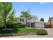 Charming home with manicured lawn, mature trees, and brick accents offers great curb appeal at 4525 S Cole Ct, Morrison, CO 80465
