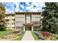 Charming condo building with inviting walkway surrounded by colorful landscaping and mature trees at 9155 E Center Ave # 10A, Denver, CO 80247