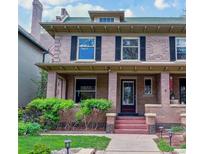 Charming two-story brick home featuring a cozy front porch and well-manicured lawn at 761 N Lafayette St, Denver, CO 80218