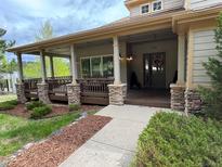 Inviting covered front porch with stone accents and a charming entrance, showcasing curb appeal at 1366 Killington Ct, Evergreen, CO 80439