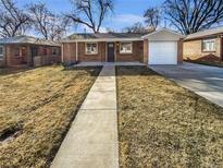 Charming brick home featuring an attached garage, neutral colors, and a well-kept front yard at 1479 S Bellaire St, Denver, CO 80222