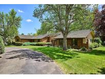 Beautiful brick home with a well-manicured lawn and mature trees creating a park-like setting at 5196 S Williams Dr, Greenwood Village, CO 80121