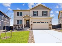 Two-story house with a gray exterior, two-car garage, and landscaped lawn at 2243 Crosswind St, Fort Lupton, CO 80621