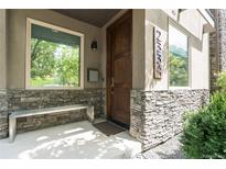 Inviting front entrance with a stone facade, wooden door, bench, and stylish architectural details at 2334 Lowell Blvd, Denver, CO 80211