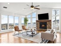 Bright living room features vaulted ceilings, a stone fireplace, and large windows with mountain views at 31969 Robinson Hill Rd, Golden, CO 80403