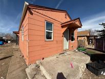 Exterior of a one story home featuring wood siding, an entry awning and a concrete porch at 723 Newton St, Denver, CO 80204