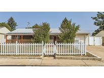 Charming single story home with a brick facade, white picket fence, and well maintained landscaping at 1101 Dakin St, Denver, CO 80221
