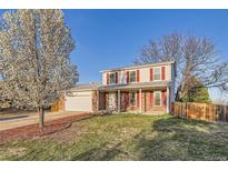 Charming two-story home featuring red shutters, brick accents, a well-maintained lawn, and mature trees at 5155 E 108Th Pl, Thornton, CO 80233