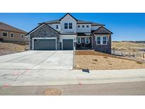 Charming two-story home with stone and white siding, three-car garage, and well-maintained landscaping at 4949 Hickory Oaks St, Castle Rock, CO 80104
