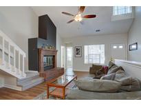 Spacious living area featuring a fireplace, staircase, and cozy seating arrangement at 3030 W Prentice Ave # G, Littleton, CO 80123