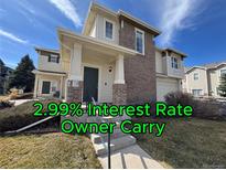 Inviting home exterior with a brick facade, covered porch, and well-manicured lawn under a bright blue sky at 13013 Grant Cir # C, Thornton, CO 80241