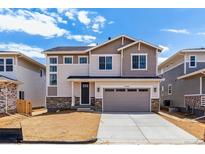 Two-story home featuring a two-car garage and a well-lit facade on a sunny day at 25284 E Warren Pl, Aurora, CO 80018
