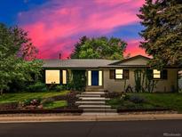 Charming home featuring a manicured lawn, white brick, blue door and lush greenery climbing on the walls at 280 E 11Th Ave, Broomfield, CO 80020
