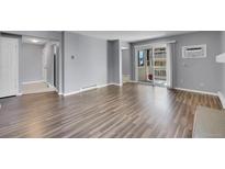 Bright living room featuring hardwood floors, neutral paint, and a sliding glass door to a balcony at 4064 S Atchison Way # 204, Aurora, CO 80014