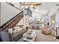Inviting living room showcases a gray sofa, a modern coffee table, and an open-concept design with views of the kitchen at 8010 Holland Ct # D, Arvada, CO 80005