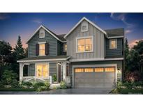 Charming two-story home featuring board and batten and horizontal siding, a porch, and a two-car garage at 199 Wooten Ave, Brighton, CO 80601