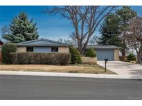 Charming single-story home featuring mature trees, brick accents, and an attached two-car garage at 7018 Reed Ct, Arvada, CO 80003