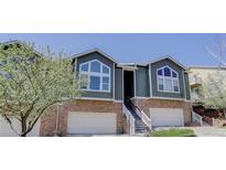 Inviting townhouse featuring an attached garage, stone accents, and a charming landscaped entrance at 6821 W Yale Ave, Lakewood, CO 80227
