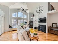 Bright living room boasts large windows, hardwood floors, and a cozy fireplace at 6821 W Yale Ave, Lakewood, CO 80227