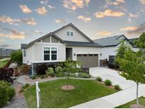 Charming home with a well-manicured lawn, beautiful landscaping, and a welcoming two-car garage at 565 Pikes View Dr, Erie, CO 80516
