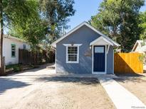 Charming, single-story home with blue exterior and a well-maintained front yard at 665 S Meade St, Denver, CO 80219