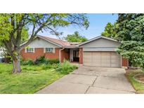 Charming single-story home featuring brick and siding, with an attached two-car garage and mature landscaping at 10330 Melody Dr, Northglenn, CO 80260