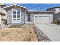 Charming single-Gathering home featuring a stone facade, a two-car garage, and professional landscaping at 24779 E 39Th Ave, Aurora, CO 80019