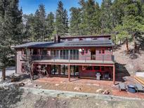 Beautiful home with large windows and a spacious balcony, nestled among tall trees at 205 Yankee Creek Trl, Evergreen, CO 80439