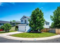 Charming two-story home featuring a well-manicured lawn and mature tree on a sunny day at 8930 Apache Plume Dr, Parker, CO 80134