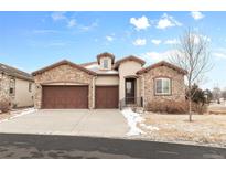 Charming stucco home with a stone facade, attached three car garage, and a well maintained lawn at 49 Willowcroft Dr, Littleton, CO 80123