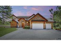 Stone-clad home with three-car garage and arched entry; professionally landscaped at 11790 Huckleberry Drive Dr, Franktown, CO 80116