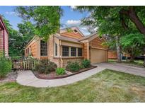 Charming exterior view of home with well-kept lawn, brick accents, and attached garage at 10262 W Ida Ave # 243, Littleton, CO 80127