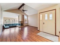Bright living room with vaulted ceilings, hardwood floors, brick fireplace, and built-in seating area at 10262 W Ida Ave # 243, Littleton, CO 80127