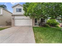 Charming two-story home featuring a brick-accented facade, mature tree, and a well-maintained front lawn at 11313 Haswell Dr, Parker, CO 80134