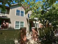 Charming townhome with a gated entrance and mature trees providing shade and curb appeal at 10035 E Mexico Ave, Aurora, CO 80247