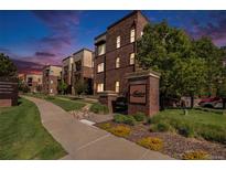 Brick apartment building with manicured landscaping and clear community signage, setting a welcoming tone at 301 Inverness S Way # 202, Englewood, CO 80112