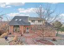 Inviting two-story brick home with a landscaped front yard and a charming brick walkway to the entrance at 767 Ellis St, Golden, CO 80401