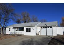 Charming one-story home featuring a clean, white exterior with a well-maintained front yard and attached garage at 5142 S Pennsylvania St, Littleton, CO 80121