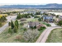Expansive aerial view of a home with a picturesque mountain backdrop and lush green surroundings at 1285 Spinnaker Trl, Monument, CO 80132