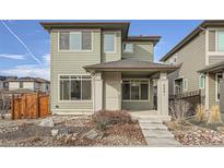 Two-story house with gray siding, stone accents, and a small front porch at 6861 Clay St, Denver, CO 80221