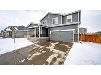 Two-story house with gray siding, attached garage, and covered porch at 47387 Lilac Ave, Bennett, CO 80102