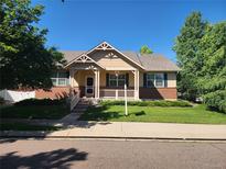 Charming single-Gathering home with a well-manicured lawn, covered front porch, and mature trees at 221 Homestead Pkwy, Longmont, CO 80504