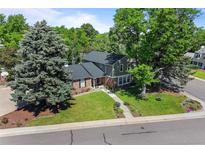 Charming home with a well-manicured lawn, mature trees, and a welcoming walkway leading to the front entrance at 5081 S Emporia St, Greenwood Village, CO 80111