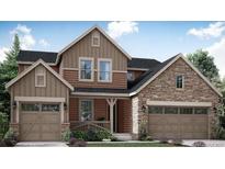 Beautiful two-story home featuring a stone and siding exterior, attached garages, and manicured landscaping at 14533 Hudson Way, Thornton, CO 80602