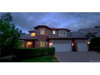 Two-story home with brick and vinyl siding, attached two car garage and landscaped yard at twilight at 518 Zircon Way, Superior, CO 80027