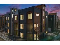 Modern townhome showcasing a stylish exterior with clean lines and a mix of dark gray and wood-tone siding at 3011 W 53Rd Ave, Denver, CO 80221
