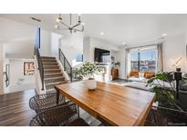 Bright living room with a staircase, a flat screen TV, and large windows offering natural light at 3011 W 53Rd Ave, Denver, CO 80221