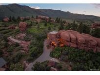 Stunning modern home seamlessly integrated with natural rock formations in a picturesque landscape at 6619 Apache Pl, Larkspur, CO 80118