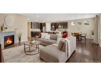 Open-concept living room showcases a cozy fireplace and flows seamlessly into the modern kitchen at 9772 Taylor River Cir, Littleton, CO 80125