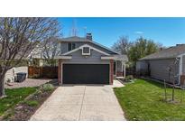 Charming two-story home with a gray exterior, a well-manicured lawn, and a two-car garage with a concrete driveway at 2330 Redwood Ave, Lafayette, CO 80026